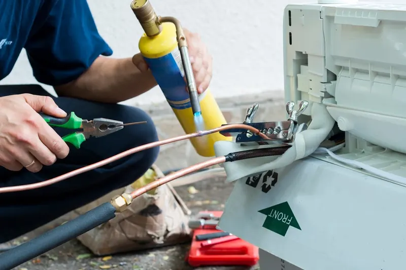 Copper refrigerant pipes being brazed during an aircon installation