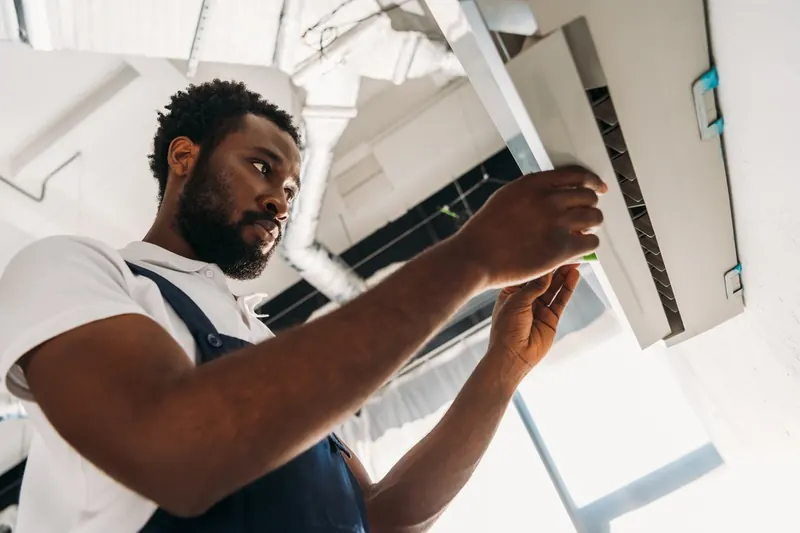 Technician working on a ceiling cassette air conditioner