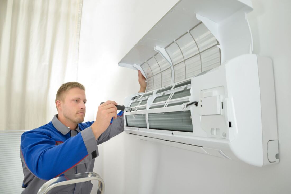 Picture of technician repairing and replacing filters on air conditioning unit